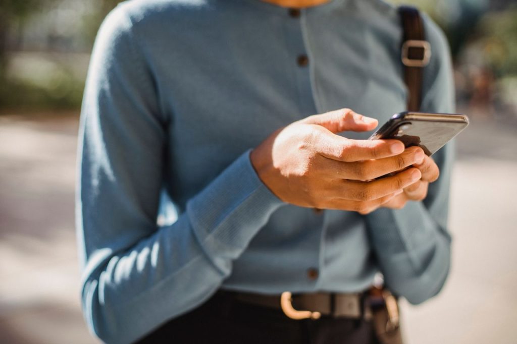 pessoa usando o celular, ilustrando como organizar a base de conhecimento para melhorar as respostas da IA